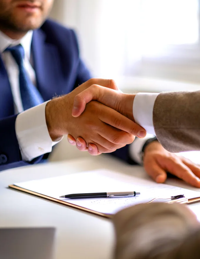 Business handshake over a signed agreement